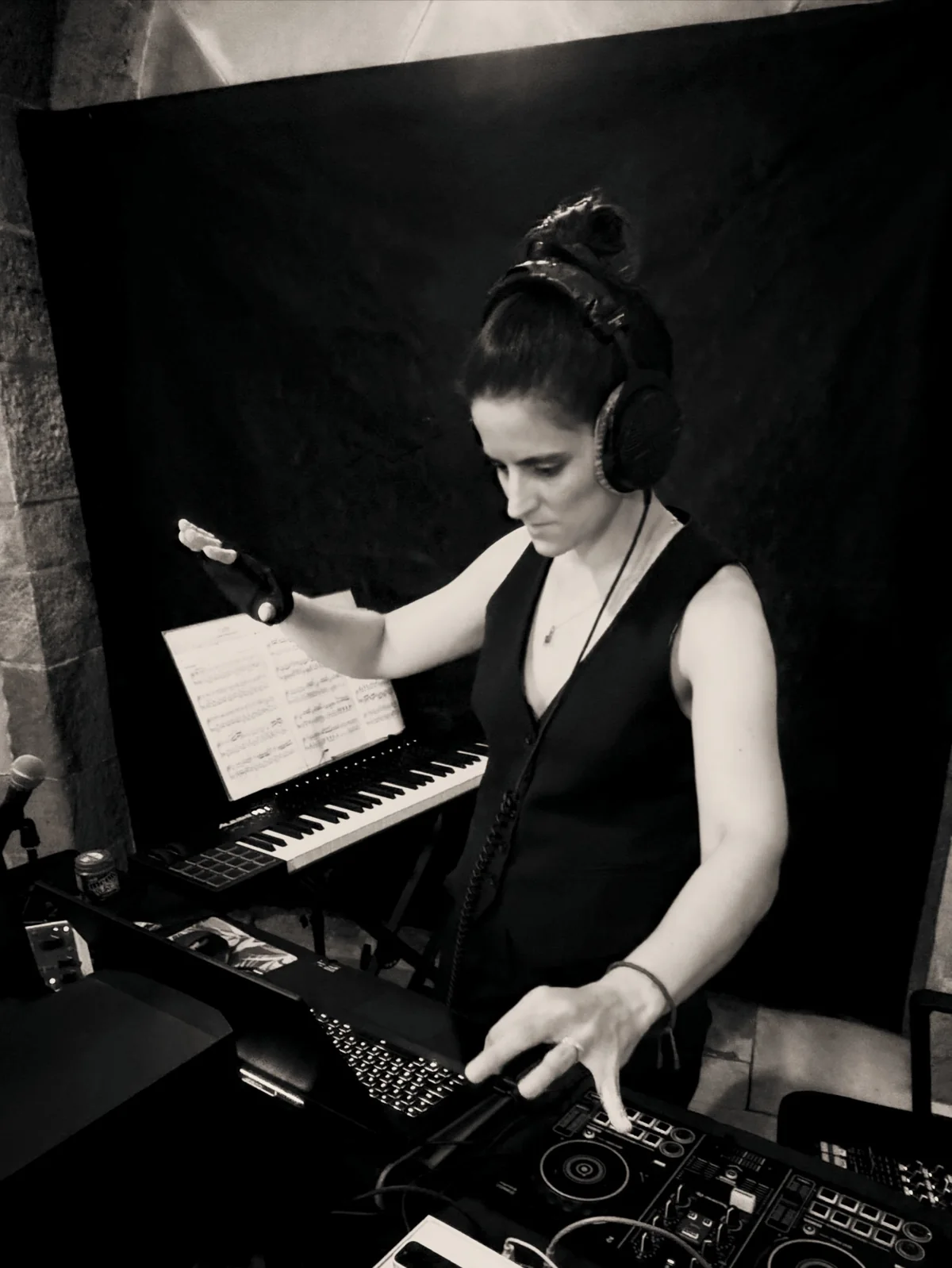 Romina Romay working in the studio with headphones and electronic instruments